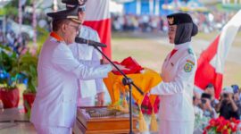 Bupati, James Uang, Menyerahkan Bendera Merah Putih Kepada Pembawa Baki Paskibraka