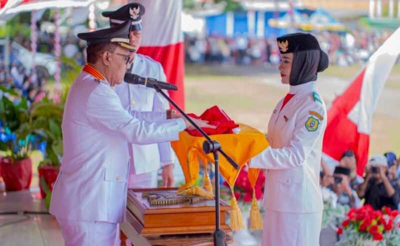 Bupati, James Uang, Menyerahkan Bendera Merah Putih Kepada Pembawa Baki Paskibraka