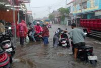 Kendaraan Yang Melintasi Genangan Air di Ruas Jalan Kelurahan Bastiong
