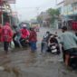 Kendaraan Yang Melintasi Genangan Air di Ruas Jalan Kelurahan Bastiong